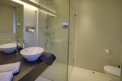 昂吉安维厄赛德勒旅馆酒店的一间带玻璃淋浴和水槽的浴室