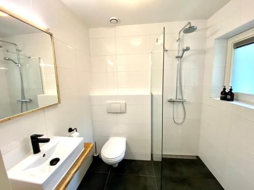 德科赫The island life texel met jacuzzi的浴室配有卫生间、盥洗盆和淋浴。