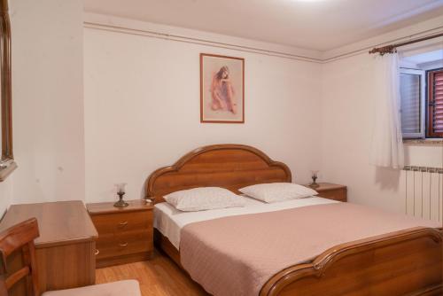 茨雷斯Rooms Ljubica的一间卧室配有一张床、一张桌子和一个窗户。