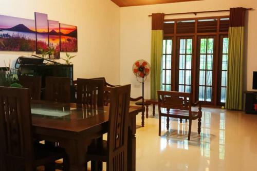 AthurugiriyaPeaceful Holiday Home的一间带木桌和椅子的用餐室