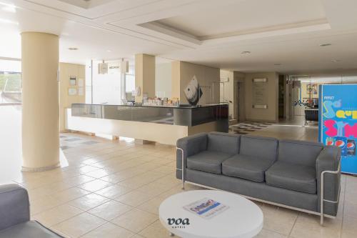阿瓜斯迪林多亚VOA Plazza Hotel的客厅配有沙发和桌子
