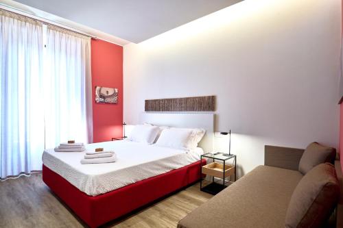 米兰DONATELLO11 Milan apartments的红色和白色的卧室,配有床和沙发
