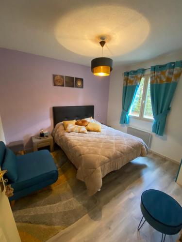 丰罗默奥代洛维亚Chaleureux appartement T4 cosy, Font Romeu Odeillo Via的一间卧室配有一张床和一张蓝色椅子