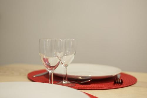 科尔马Les coquelicots, calme, jardin的两杯酒和一张桌子上的盘子