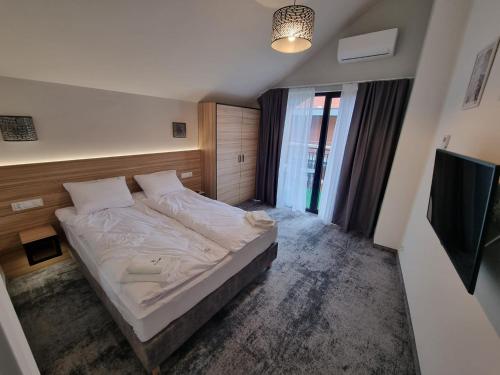 尼彻兹Domki Gold-Time Niechorze的一间卧室配有一张床和一台电视