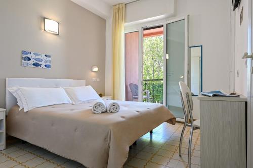 佩萨罗Amadei Hotel Promenade的一间卧室配有一张大床和两条毛巾