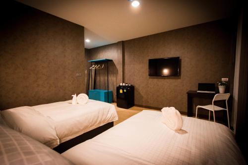 曼谷曼谷C U酒店 - SHA Plus的酒店客房设有两张床和电视。