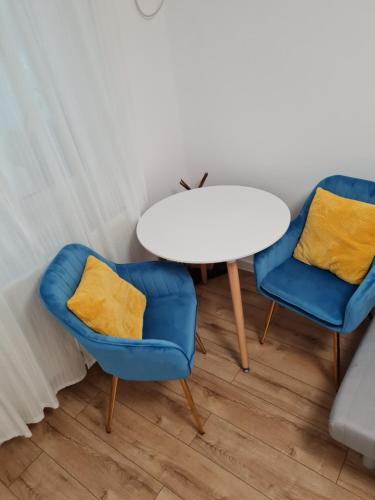 布加勒斯特Cozy Garden Residence的两个蓝色的椅子和一个白色的桌子