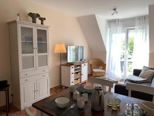KirchdorfSeerose的客厅配有大型白色橱柜和桌子