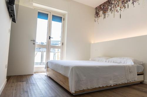 佩斯卡拉DOMUS PINAE Casa vacanze的白色的卧室设有床和大窗户