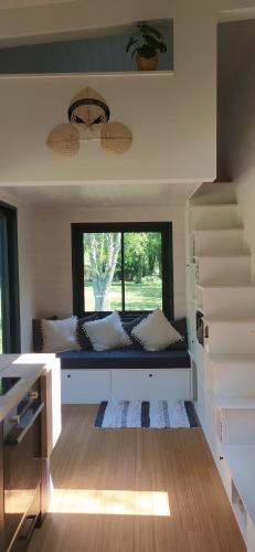 Gaillan-en-MédocTiny house chez Caroline的带沙发和窗户的客厅