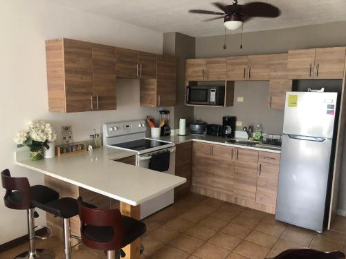 利比里亚Apartamento Chorotega的厨房配有木制橱柜和白色冰箱。