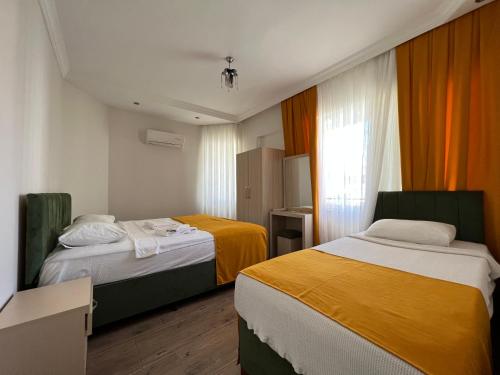 阿拉尼亚Alanya Queen Apart Otel的酒店客房设有两张床和窗户。