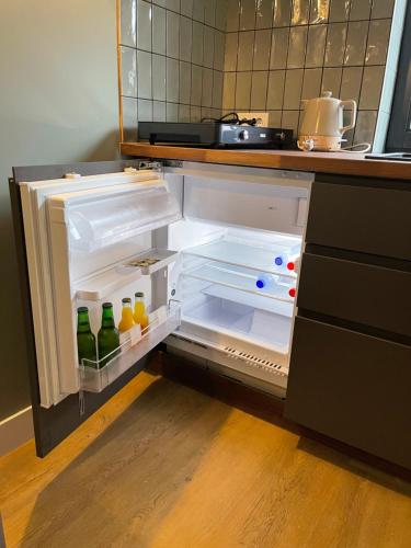 NieuwkoopB&B De Meije的厨房里配有带饮品的开放式冰箱