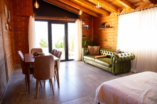 Buq‘ātāGrand Golan Cabins的一间带桌子和沙发的卧室以及一间带床的卧室。