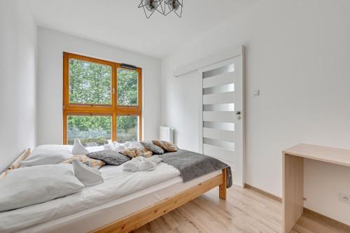 格但斯克Wave Apartments - Zajezdnia Wrzeszcz 4的白色的卧室设有一张大床和一个窗户