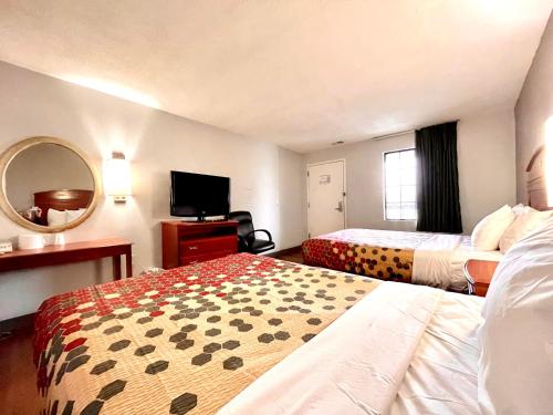 LesterRed Carpet Inn Philadelphia Airport的酒店客房设有两张床和一台平面电视。