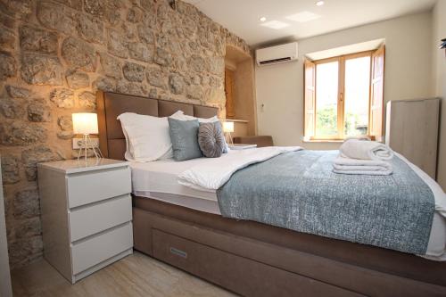 杜布罗夫尼克Ella la Bella III Dubrovnik Old town的一间卧室设有一张床和石墙