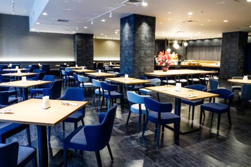 金泽金泽大酒店的一间配备有桌子和蓝色椅子的用餐室