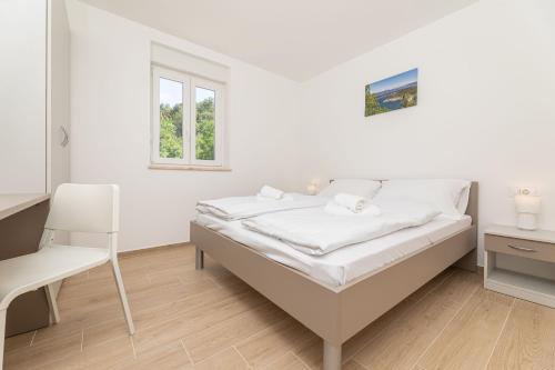 索利纳Apartments Sucic 2的白色卧室配有床和椅子