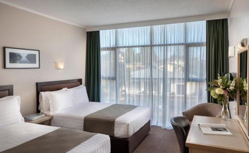 罗托鲁瓦Rydges Rotorua的酒店客房设有两张床和窗户。