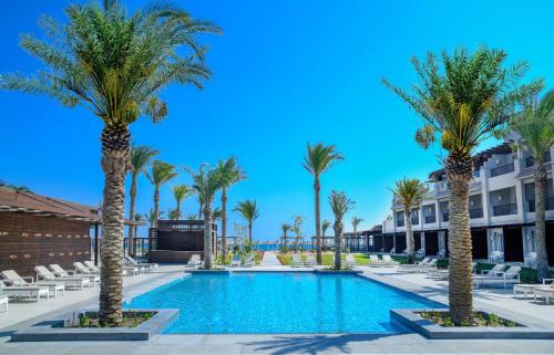 马萨阿拉姆IBEROTEL Costa Mares的一个带棕榈树和躺椅的度假游泳池
