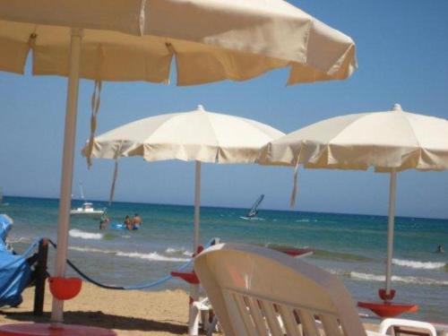 三泉Casa Militello 74的海滩上的两把白色遮阳伞和椅子