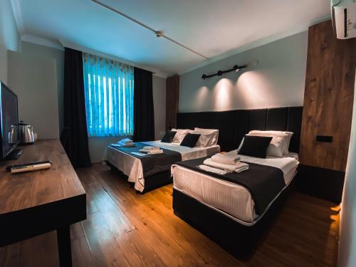 安塔利亚TEPE HOTEL&BUSINESS SUITE的酒店客房配有两张床和一张书桌