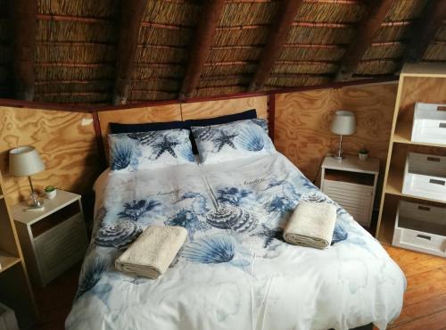 DwarskersbosSlakkepas 52的一间卧室配有一张床,上面有两条毛巾