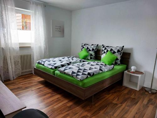 巴特贝林根Haus Kramer的一间卧室配有一张带绿色和白色棉被的床