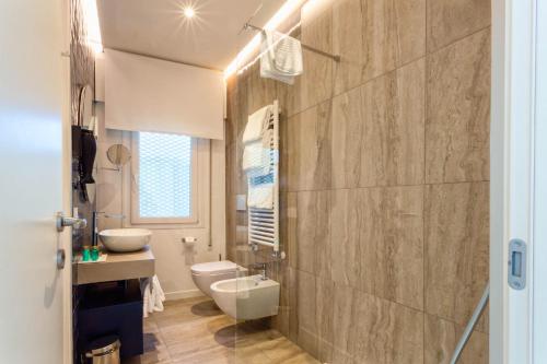 威尼斯丽都Hotel Petit Palais的浴室配有白色卫生间和盥洗盆。