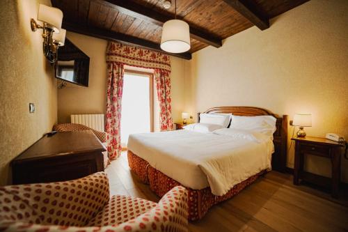 布勒伊-切尔维尼亚朱梅奥克斯酒店的一间卧室设有一张大床和一个窗户。