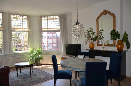 海牙Huize Maurits的客厅配有桌椅和电视。