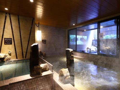 御殿场市天然温泉富士樱之汤御殿场多米快捷酒店(Dormy Inn Express Fujisan Gotemba)的一座建筑里一片岩石水
