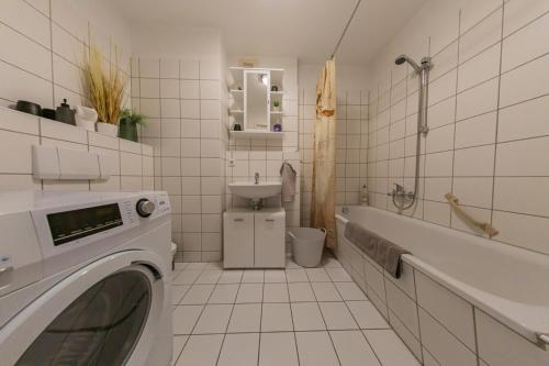 科特布斯Spreewald-Apartment, 75qm, 2 Schlafzimmer, Tiefgarage, Balkon, Netflix, Waschtrockner的白色瓷砖浴室设有洗衣机。