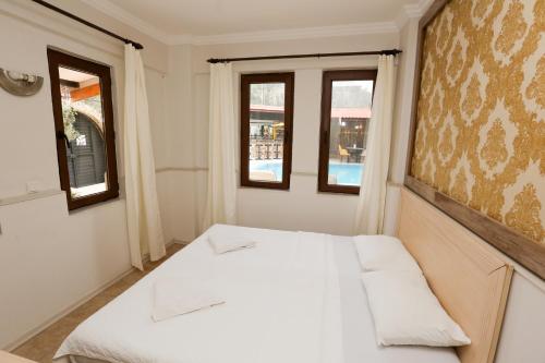 达利安Dalyan M Otel的带2扇窗户的客房内的一张白色床