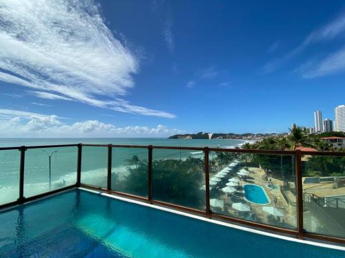 纳塔尔Araçá Praia Flat - Ponta Negra的阳台设有俯瞰大海的游泳池