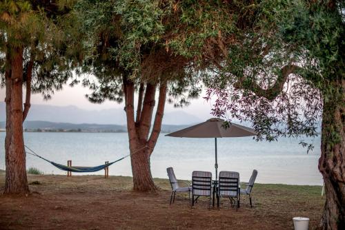 普雷韦扎Kiani Akti Villas的海滩上的两把椅子和一把遮阳伞