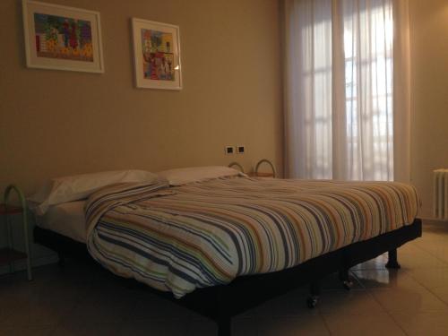 奥尔塔圣朱利奥Casa Vacanza Piazza的一间卧室配有一张床,床上有条纹毯子