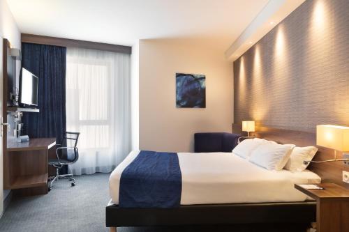 土伦Holiday Inn Express Toulon - Est, an IHG Hotel的配有一张床和一张书桌的酒店客房