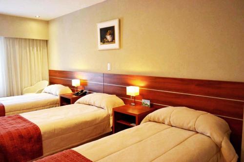 科尔多瓦Quorum Córdoba Hotel, Resort Urbano的酒店客房设有两张床和两盏灯。