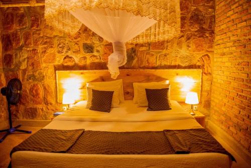 AkageraAkagera Transit Lodge的卧室设有一张砖墙内的大床
