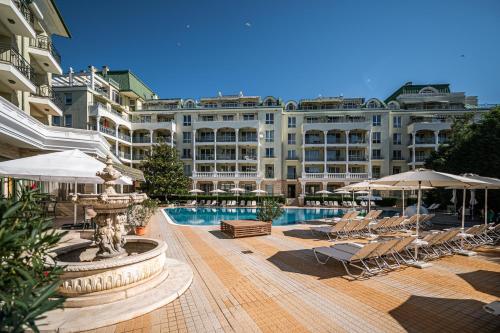 圣君士坦丁和海伦那Romance Hotel and Family Suites的大型酒店,设有游泳池、椅子和遮阳伞