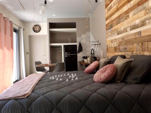 伊斯特尔La Suite Côté Pool-House Piscine, Sauna & Jacuzzi privatifs的一间卧室设有一张带木墙的大床