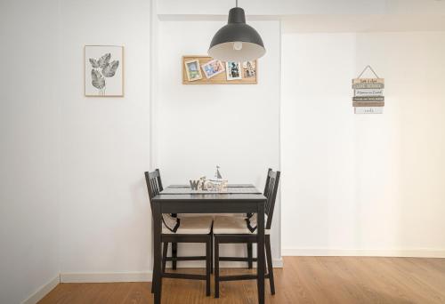 奥维多Apartamento BS Oviedo Centro的餐桌,配有两把椅子和一盏灯
