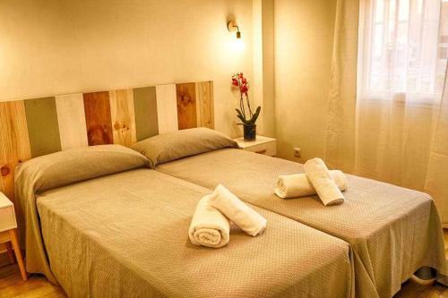 马德里Apartamento nuevo zonas Barajas Ifema Wanda的卧室内的床上的两条毛巾