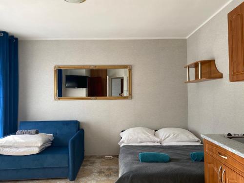 库瑞尼卡慕斯卡Twój Port的一间卧室配有蓝色的沙发和镜子