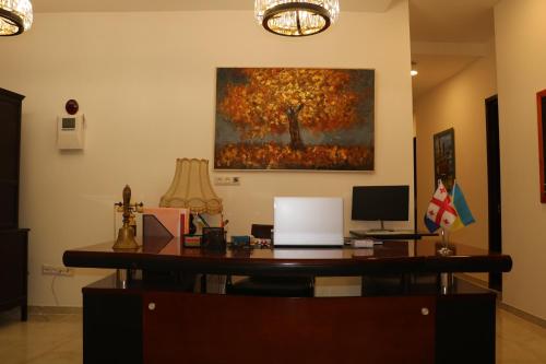 库塔伊西Hotel Verdzi的办公室,墙上有画作,配有书桌