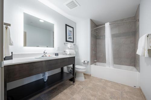 霍顿Independence Stay Hotel and Long term suites的一间带水槽、卫生间和镜子的浴室