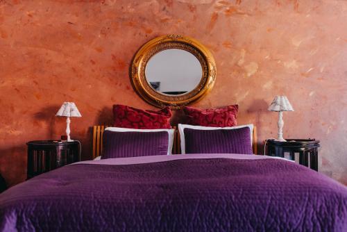 克雷姆尼察维扎旅馆的一间卧室配有一张紫色的床和镜子